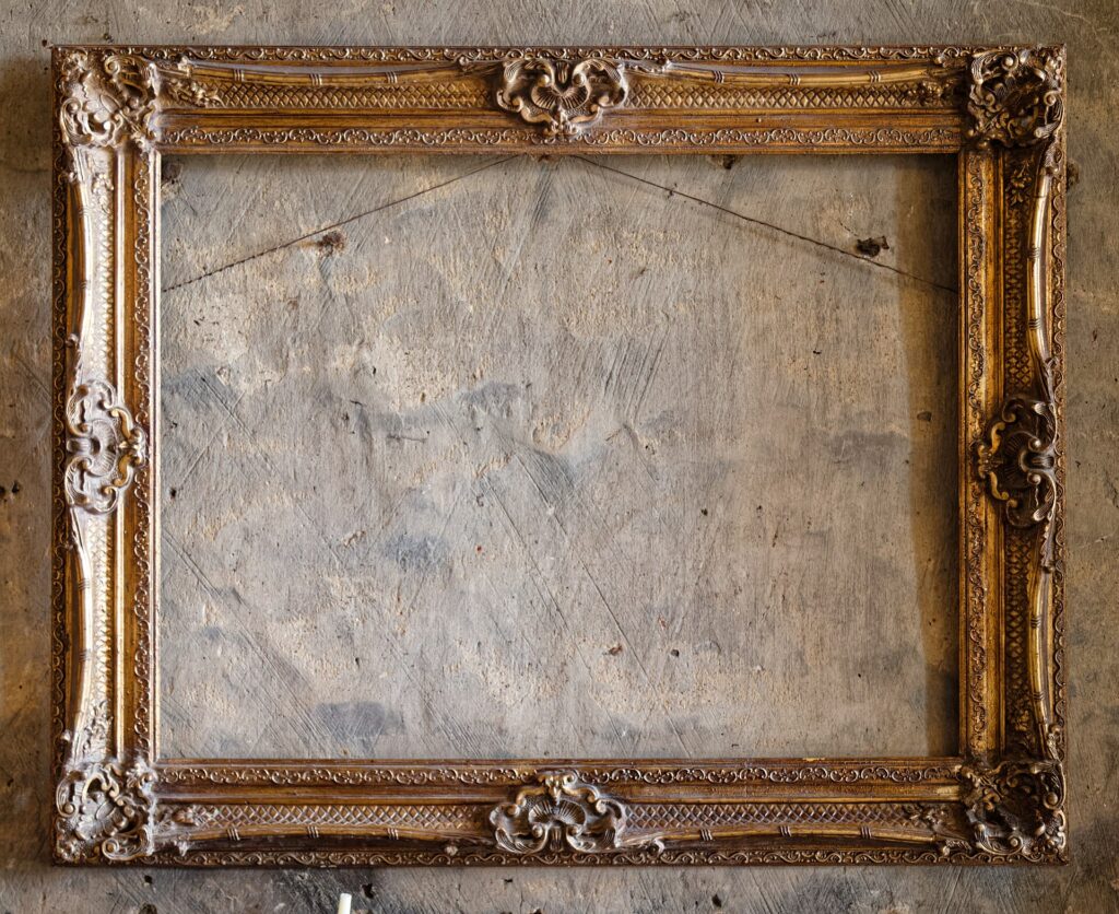 Cornice vuota appesa a una parete chiara con l'ombra proiettata sul muro
