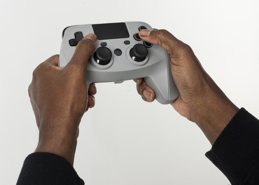 Controller da videogioco appoggiato su un tavolo accanto a uno schermo acceso