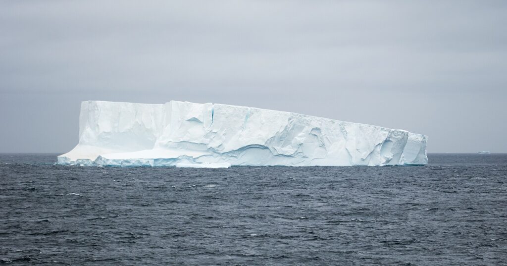 Iceberg che emerge dall'acqua con la massa maggiore nascosta sotto la superficie