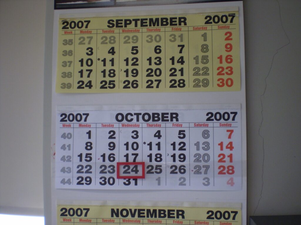 Calendario da parete appeso accanto a una scrivania con i giorni del mese in evidenza