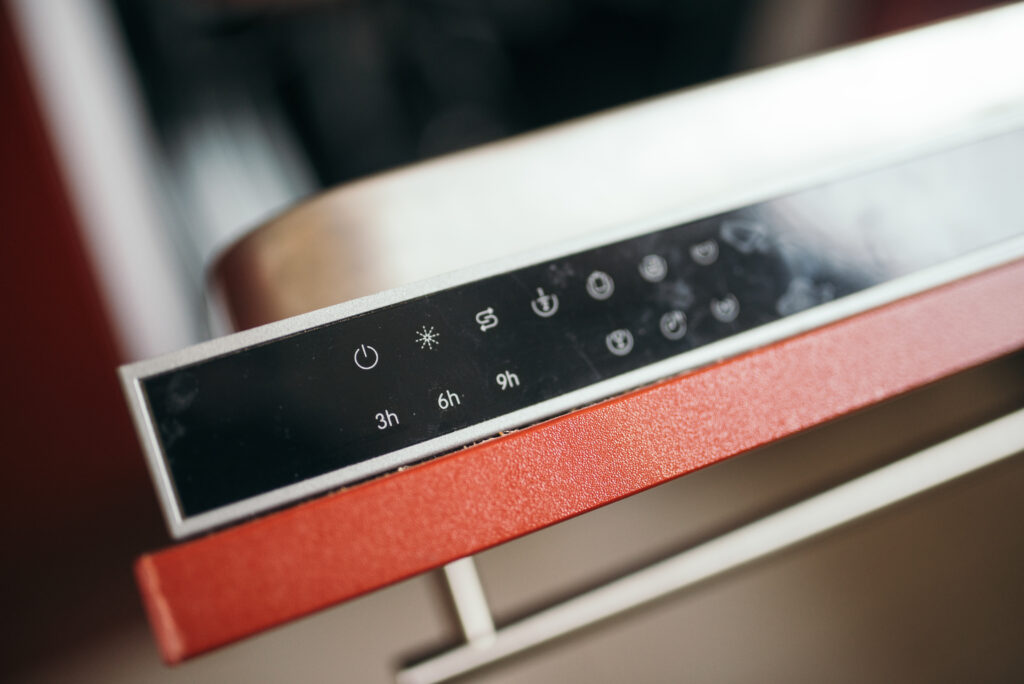 Timer meccanico da cucina appoggiato su un piano chiaro accanto a un blocco per appunti