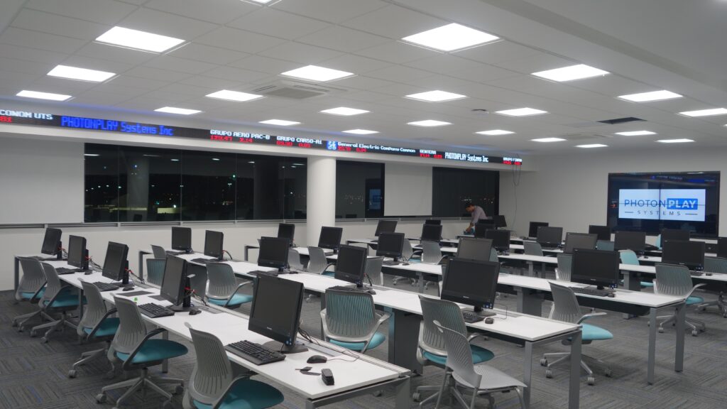 Tabellone elettronico con quotazioni in scorrimento su fondo scuro dentro una sala