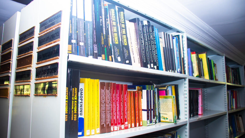 Volumi di diritto rilegati allineati su uno scaffale di legno in una biblioteca