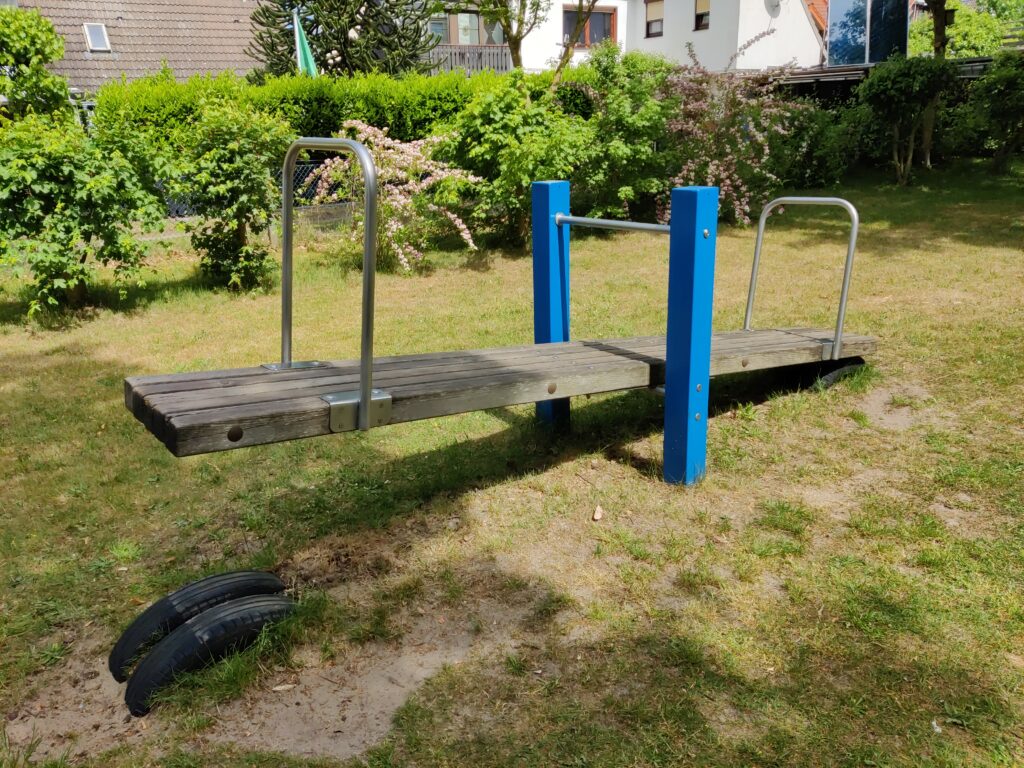 Altalena a bilico in un parco giochi vuoto ripresa da vicino contro la ghiaia
