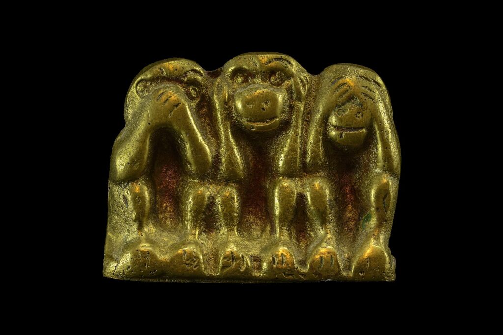 Tre chiavi di ottone di forme diverse appoggiate su un piano di legno scuro