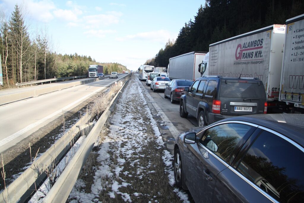 Fila di automobili incolonnate su un'autostrada vista dall'alto al tramonto