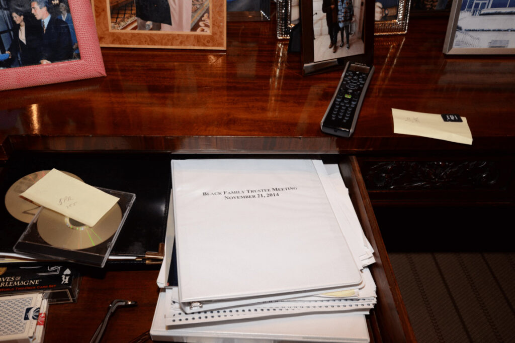 Pila di documenti legali rilegati appoggiata su una scrivania in ufficio