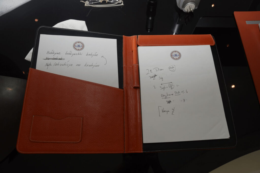 Quaderno aperto con equazioni scritte a mano e una penna appoggiata sul margine