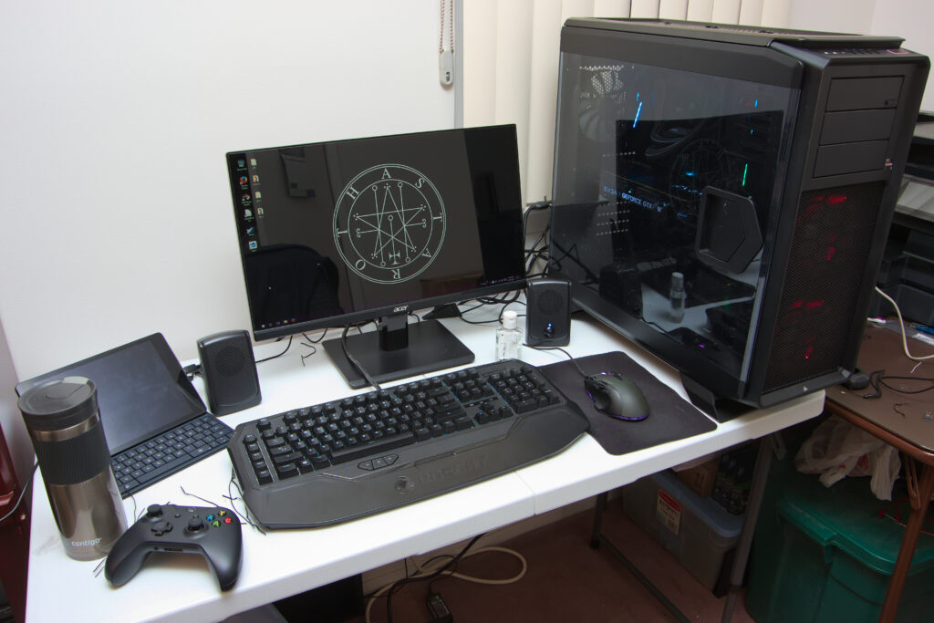 Postazione da gioco con monitor acceso e tastiera meccanica illuminata