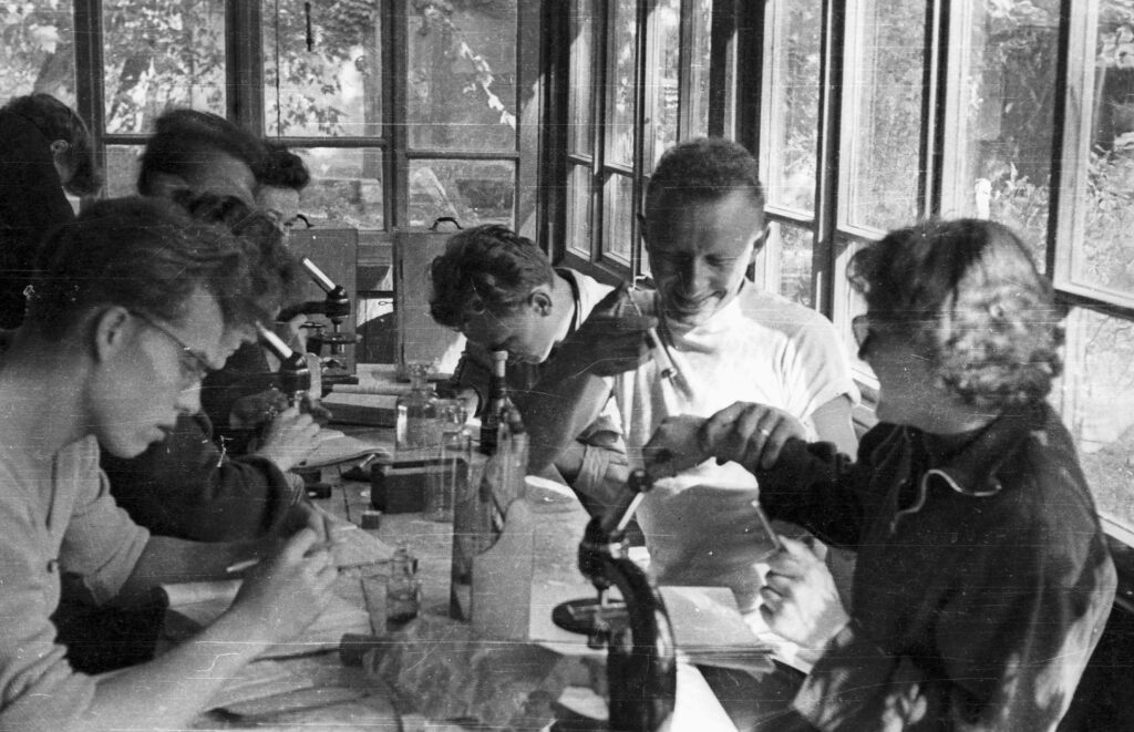 Microscopio ottico su un banco di laboratorio con vetrini disposti accanto alla base