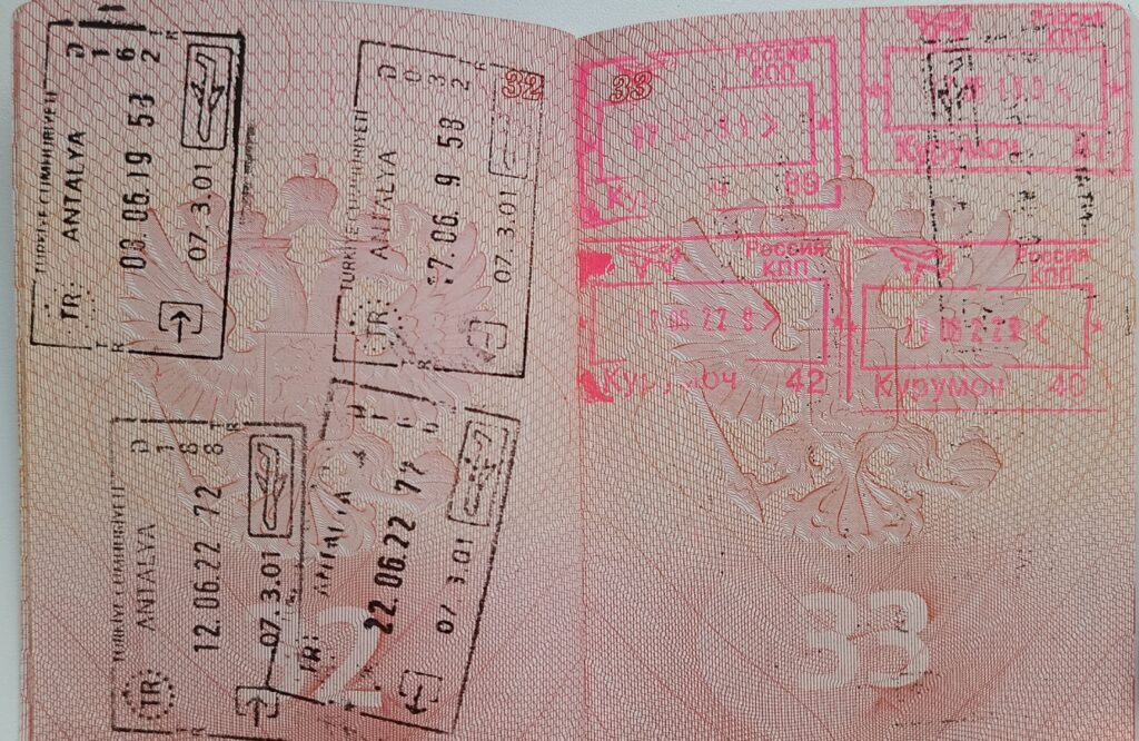 Passaporto aperto su una pagina coperta di timbri di ingresso appoggiato su un banco